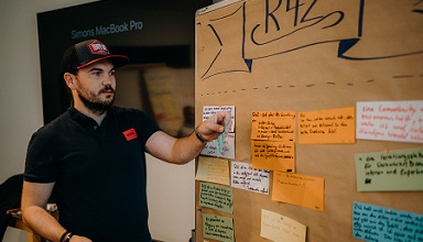 CEO Siebenhüner steht vor einem Board mit Postits
