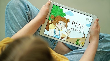 Ein Kind hält ein Tablet in den Händen und PiAS Lernreise