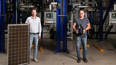 Die beiden Gründer von LuxChemtech mit einer Photovoltaikplatte